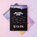 Black 'My Camp Autograph Book' with names on a pink background