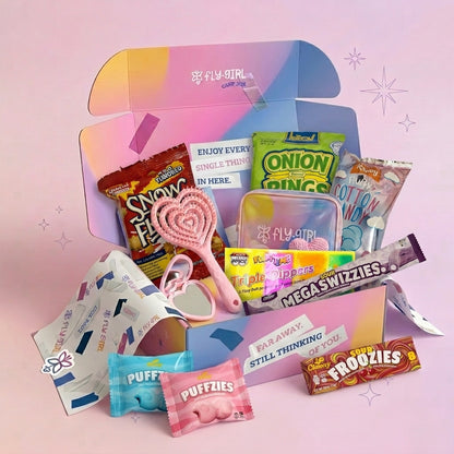 Open box with various snacks and stationery items on a pink background