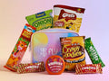 Assorted snack packages including Lay's, Singit, and Twizlers with a branded pouch on a light pink background.