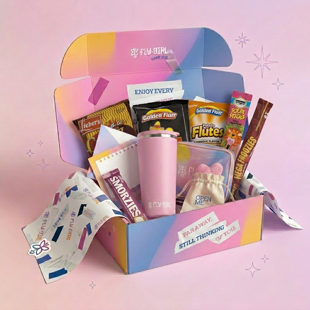 Colorful gift box with snacks and a pink tumbler on a pink background