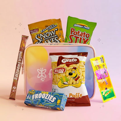 A curated snack assortment arranged around a pastel iridescent zip pouch on a soft pink background. Visible items include a bag of Shuffler Snow Cakes, a bag of Golden Fruit Potato Stix, a bag of Gusto Puffs, a bar of Mega Froylizes, and a bag of Sour Froylizes.