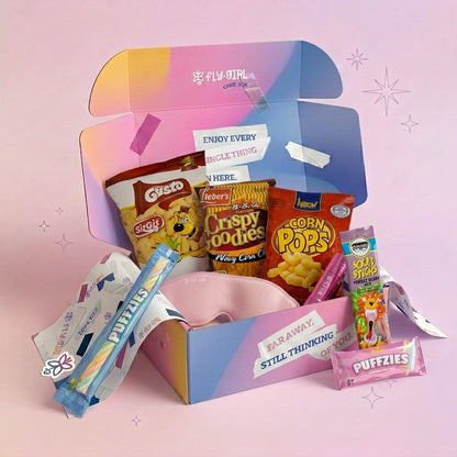 Snack box with various chips and snacks on a pink background