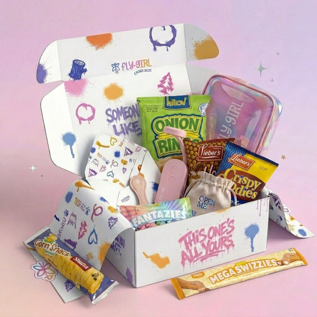Open box with various snacks and stationery items on a pink background