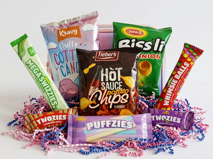 Assorted snack packages including hot sauce potato chips, candy bars, and other treats on a white background.