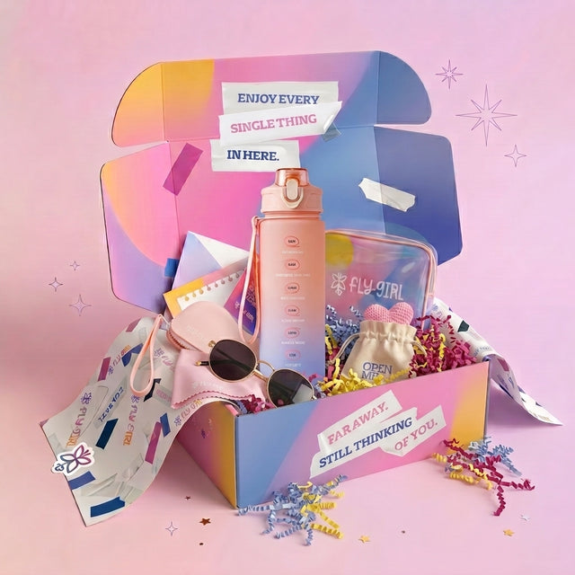 A pastel gift box filled with assorted fashion accessories on a pink background. The box is open and decorated with colorful geometric graphics and text stickers.